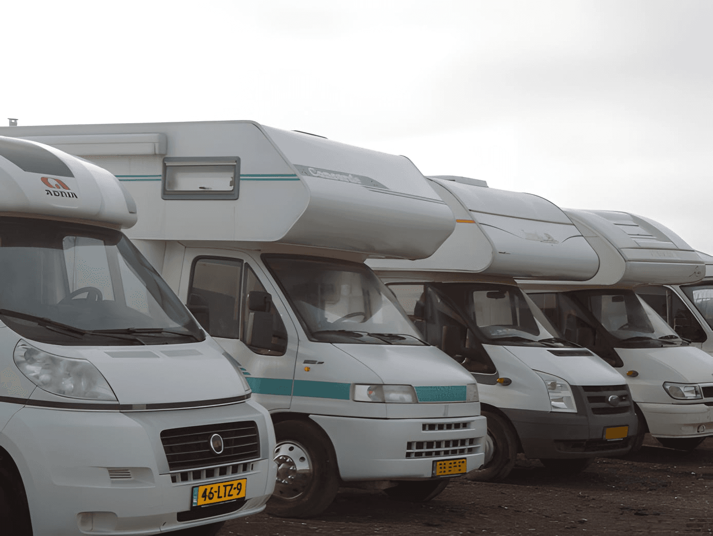 Vier campers naast elkaar geparkeerd op de stalling