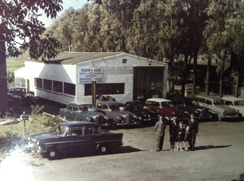 Garagebedrijf Rigter en Hack met auto's op het erf, foto uit 1962